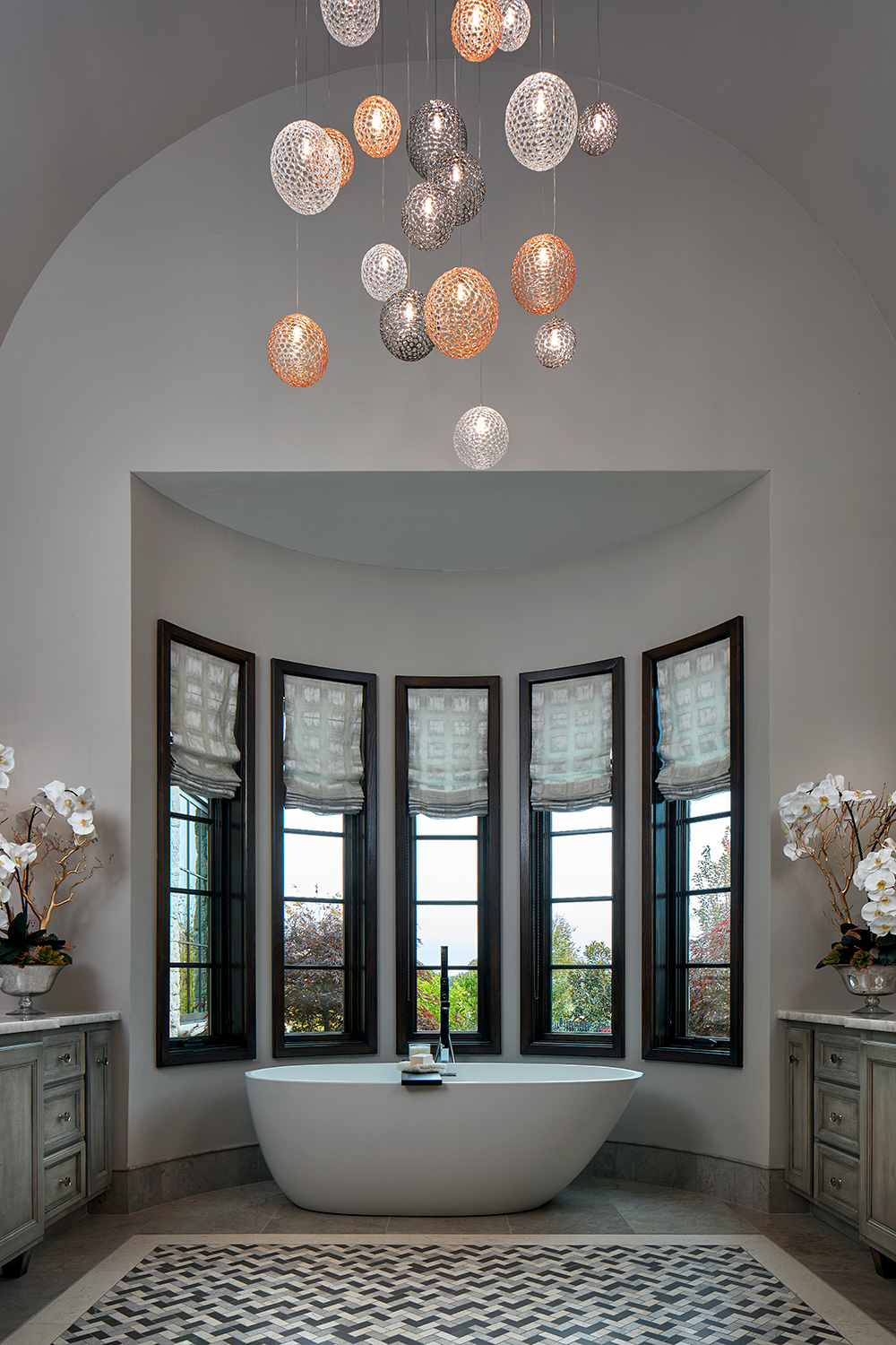 luxurious master bath with custom chandelier and white soaking tub