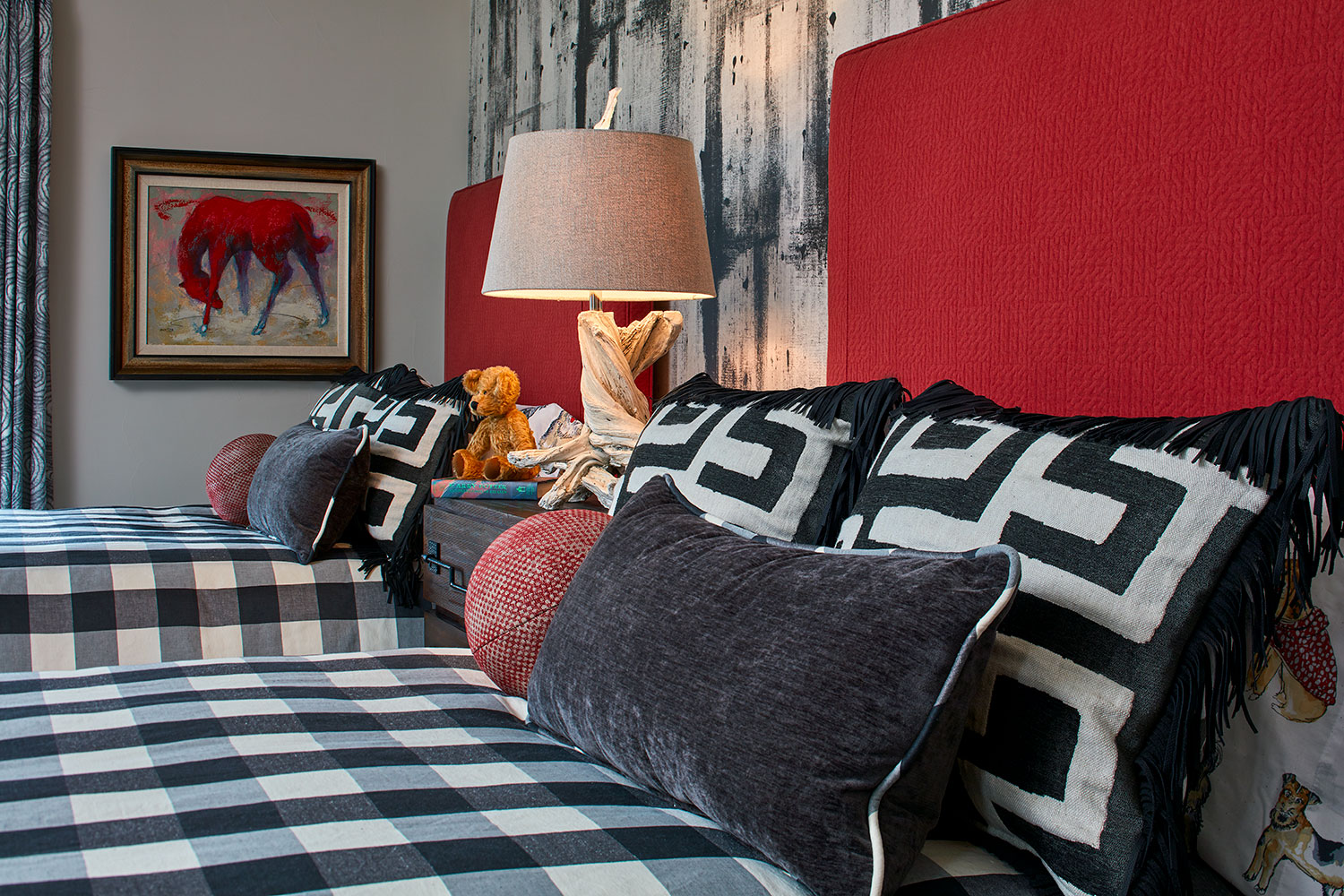 bed with red headboard and bold graphic black and white prints