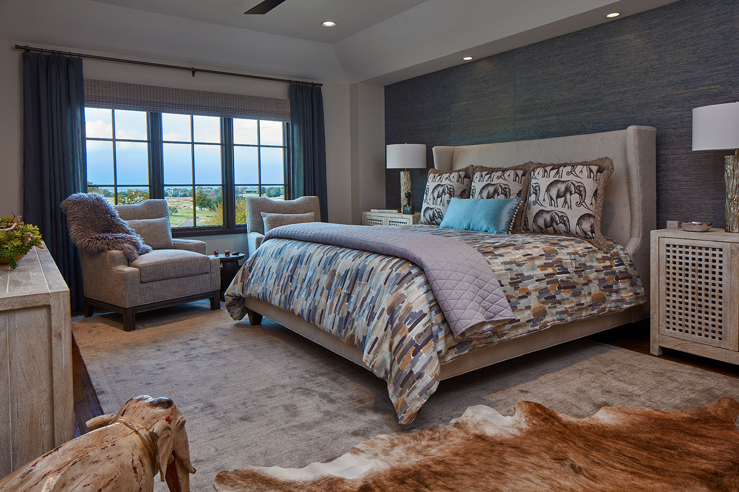 Blue and Beige Bedroom with Cow Hide Rug and Elephant Accents