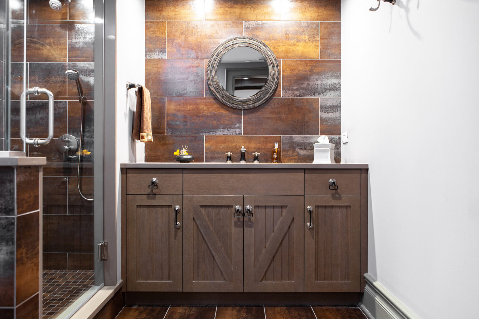 dark wood vanity with multi-colored tile backsplash in orange and rust tones