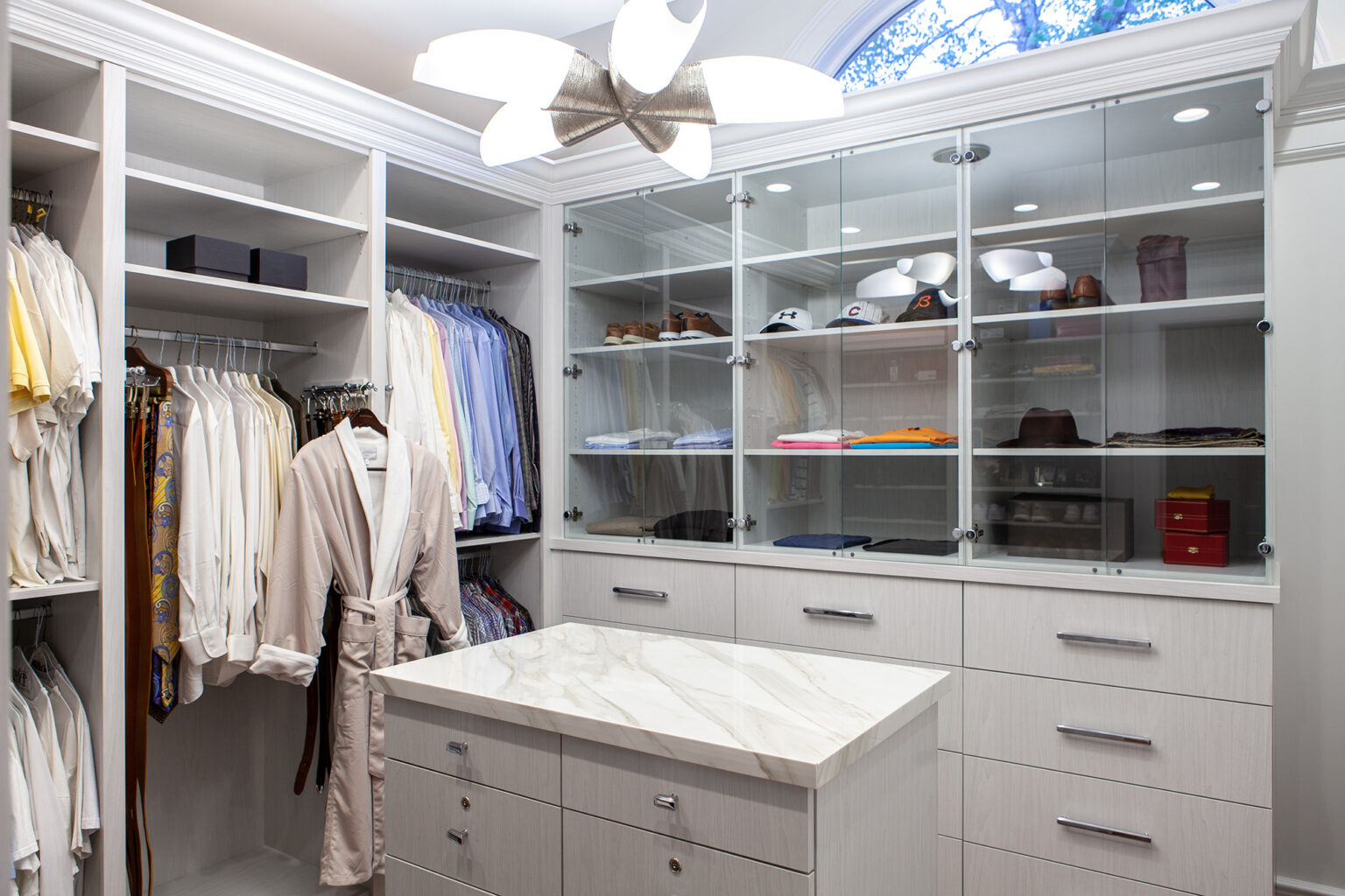 custom closet with off white cabinetry and glass doors